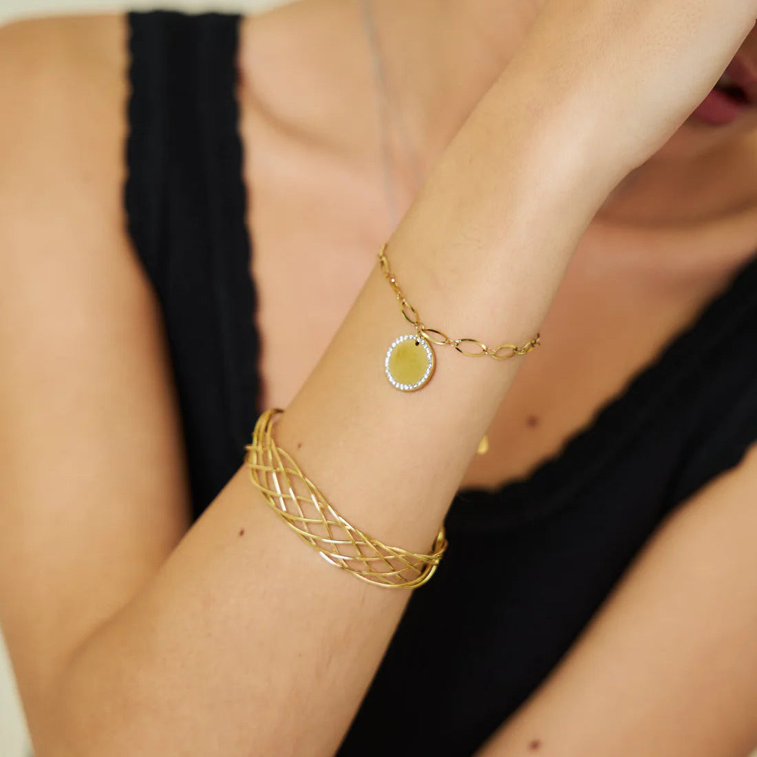Jonc Lily doré porté au poignet, fils tressés multifils en acier inoxydable 316L, superposé avec un bracelet chaîne doré à médaillon – FLIDEA Jewelry