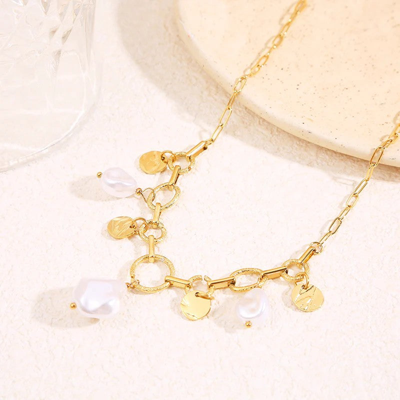 Gros plan du collier Vaya doré à maillons avec médaillons martelés et perles blanches