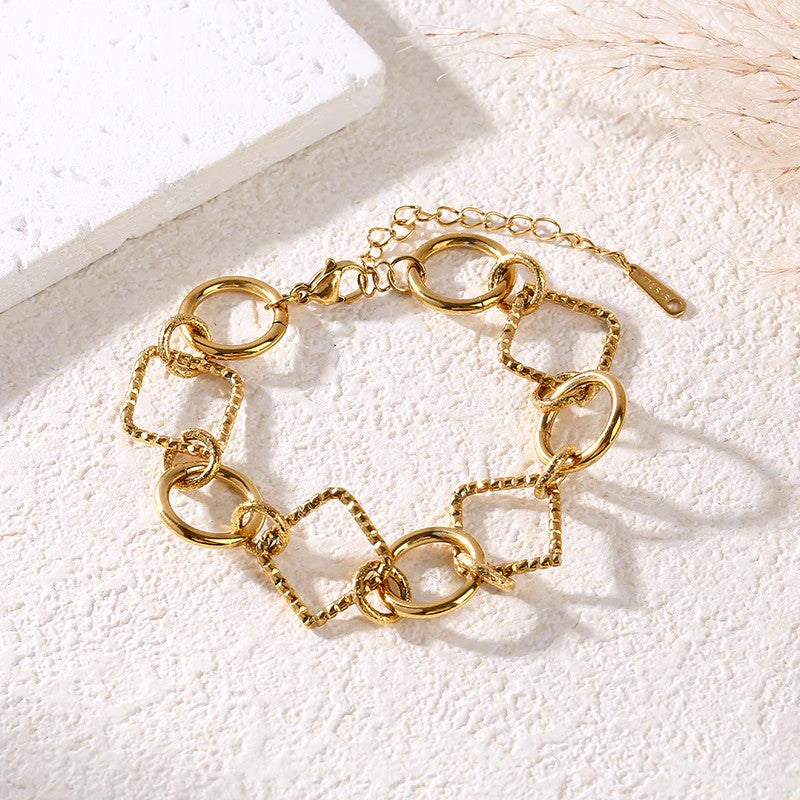Bracelet Lizia doré à maillons ronds et carrés sur fond blanc texturé
