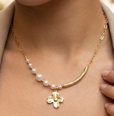 Gros plan du collier Églantine doré avec perles blanches et pendentif fleur porté