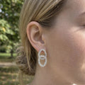 Boucles d'oreilles Agathe argentées portées à l'oreille – doubles cercles scintillants en acier inoxydable 316L