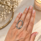 Bague Jayanti argentée ajustable en acier inoxydable 316L vue de près entre les doigts