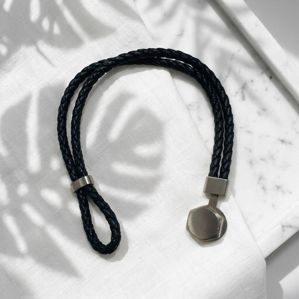 Bracelet Atlas homme en cuir noir avec fermoir noir en acier inoxydable 316L posé sur un décor clair